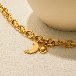 Macro shot of 18K gold-plated chunky chain with black enamel moon and bead pendants