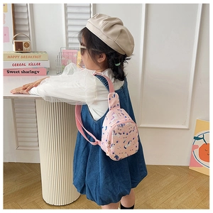 Pink unicorn canvas chest bag for kids worn by a model in a bright home setting