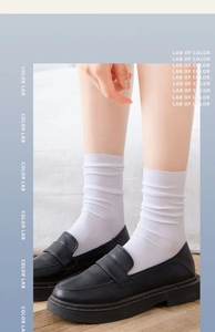 Detailed knit texture of white vertical stripe crew socks with black leather loafers