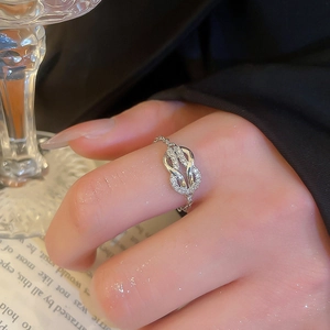 Macro shot of silver horseshoe chain ring with pavé zircon infinity knot on a hand