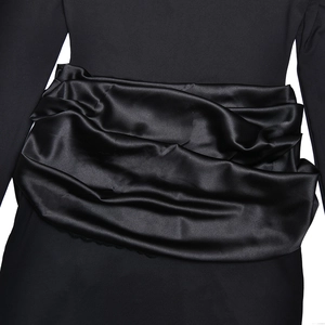 Detailed view of elegant black satin waist pleats with a smooth silky texture and shine