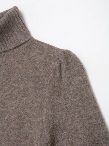 Close-up of high neck ribbed knit detail and soft oatmeal fiber texture on sweater