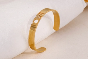 Macro shot of gold-plated LOVE open bangle featuring sparkling rhinestones on the letter V