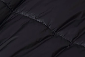 Close-up of black quilted winter coat showing stitching tension and fabric texture