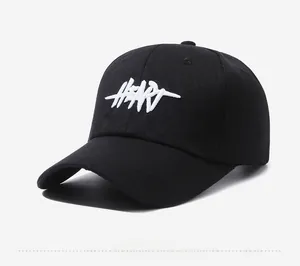 Detail of a black cotton baseball cap showing white HEART 3D embroidery and twill texture