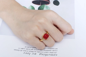 Detail of a vintage gold titanium ring featuring a large square red zircon stone on hand