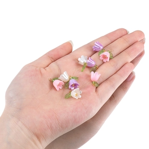 Handheld view of 15mm lily of the valley pearl pendants in pink, purple, and white colors
