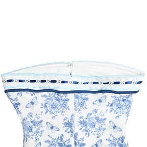 Detail of floral printed top featuring white lace trim, blue ribbon, and back zipper
