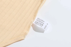 Close-up of garment wash label showing 95% cotton fabric composition and care symbols