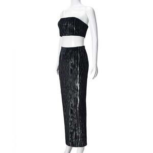 Détail d'un ensemble deux pièces noir plissé avec haut bandeau et jupe longue taille haute