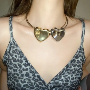 Close-up of model wearing gold and silver double heart pendant choker necklace set