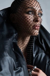 Close-up of black elastic fishnet headpiece with rhinestones and silver rings