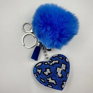 Close-up of blue leopard print heart pendant with sparkling rhinestones and plush pompom