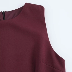 Detail of burgundy sleeveless dress featuring a back invisible zipper and textured fabric