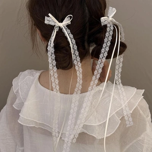 Chic cream lace bow hairpins with long ribbons worn by a girl for a ballet-style look