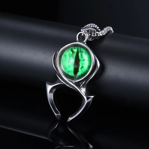 Détail macro d'un pendentif griffe gothique avec œil de dragon vert mystique et métal argent