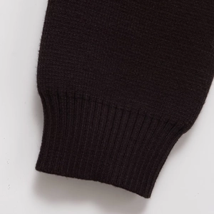 Close-up of rib-knit cuffs on a minimalist autumn sweater in deep charcoal brown