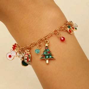 Close-up of golden Christmas charm bracelet with reindeer and tree charms on wrist
