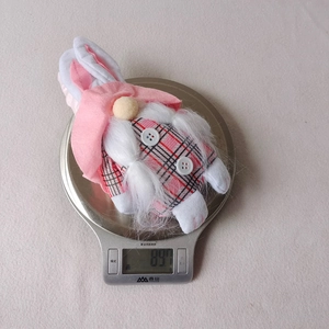 Easter gnome plush doll with pink bunny ears on a scale showing 89.7g weight