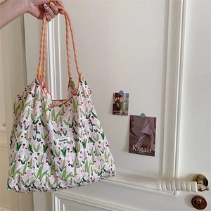 Detail of floral canvas tote bag with pink tulips and orange braided rope handles