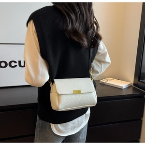 Détail d'un sac à bandoulière blanc à motif litchi avec fermoir doré et large sangle