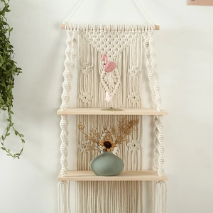 Detail of two-tier macrame wall shelf with hand-woven cotton rope and natural wood
