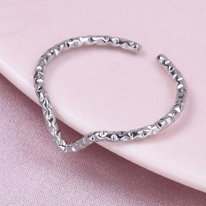 Macro shot of silver minimalist adjustable wavy ring with hammered texture on pink silk
