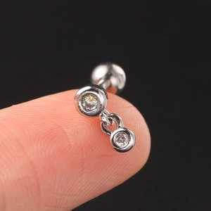 Macro shot of silver stainless steel cartilage stud with two sparkling cubic zirconia stones