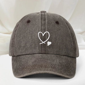 Detailed view of white heart embroidery on a vintage charcoal washed cotton baseball cap