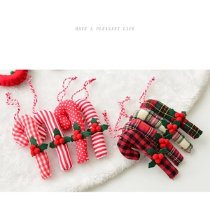 Detail of fabric candy cane Christmas ornaments with holly leaves and red berry accents