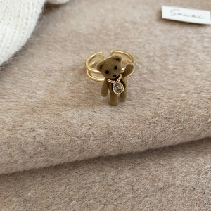 Detail of 18K gold double-layer open ring with brown flocked bear and teardrop crystal