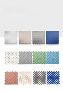Detail of interlocking TPE bathroom floor mats showing various colors and drainage holes