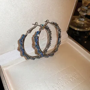 Chic silver hoop earrings with blue rhinestones displayed in a premium jewelry gift box