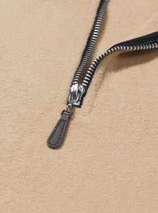 Detailed macro view of the silver metal zipper on premium camel fleece sweatshirt fabric