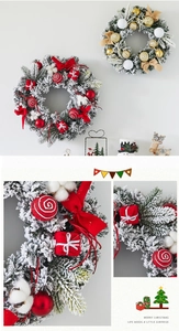 Close-up of PVC Christmas wreath with red bows, snowy pine needles and gift box ornaments