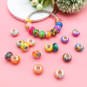Detailed view of colorful ink-painted resin beads on a silver charm bracelet