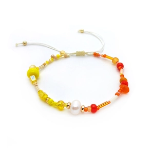Macro detail of handmade colorful beads with a natural freshwater pearl and adjustable cord