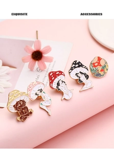Detailed view of handmade enamel mushroom girl pins on a pink decorative display stand