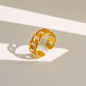 Détail d'une bague dorée avec texture de chaîne gourmette et anneau ouvert ajustable