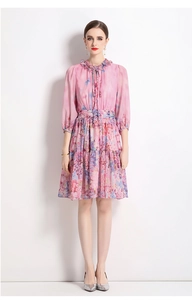 Detail of floral chiffon dress with ruffled neck, lantern sleeves, and layered hemline