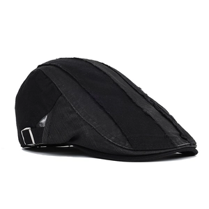 Detail of vintage black beret featuring side adjustable metal buckle and canvas texture