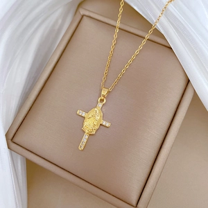 Detail showing the gold cross pendant with crystal inlay and relief on silk background
