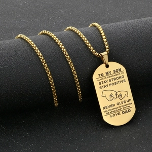 Vue macro d'un collier plaque militaire dorée pour fils avec citation motivante gravée