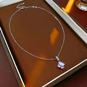 Détail du collier trèfle argenté avec pétales en pierres précieuses violettes