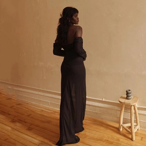 Vista posteriore dell'abito nero a maniche lunghe scollato con un elegante drappeggio lungo