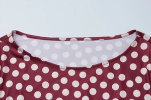 Detailed macro view of the round neckline on a red and white polka dot summer dress