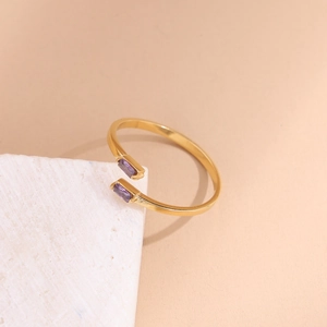 Detail of a gold plated stainless steel open ring featuring two purple rectangular zircons