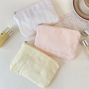 Three-piece quilted cosmetic bags with vertical lace patterns and metal zipper detail