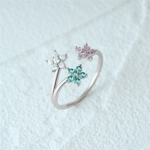 Detailed close-up of a silver adjustable ring featuring three colorful floral gemstone motifs