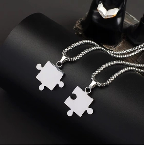 Polished titanium steel puzzle necklaces for couples on dark cylindrical display